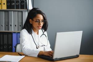 gezondheidszorg, medisch en technologie concept - Afrikaanse vrouw dokter met laptop foto