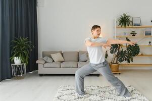 middelbare leeftijd vrouw aan het doen yoga Bij huis voor uitrekken en wezen gezond. foto
