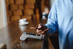 volwassen zakenman betalen met contactloos credit kaart met nfc technologie. foto