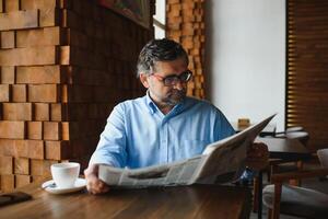 koffie pauze. Mens drinken koffie en lezing krant- in cafe bar foto