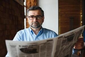 koffie pauze. Mens drinken koffie en lezing krant- in cafe bar foto