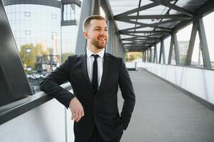 effectenmakelaar in de buurt de kantoor. een geslaagd en Geavanceerd knap bedrijf Mens in een pak looks omhoog in voorkant van hem staand Aan de achtergrond van beton stappen. foto