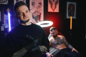 portret van tatoeëren artiest staand binnen salon foto