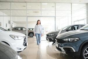 jong bedrijf vrouw kiezen een auto in een auto salon foto