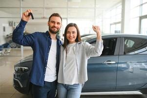 gelukkig jong paar kiest en buying een nieuw auto voor de familie. op bezoek de handel foto