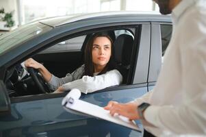 vriendelijk voertuig handelaar tonen jong vrouw nieuw auto foto