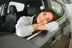 gelukkig vrouw het rijden een auto en lachend. schattig jong succes gelukkig brunette vrouw is het rijden een auto. foto