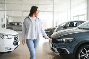 gelukkig vrouw klant vrouw koper cliënt Kiezen auto willen naar kopen nieuw auto- in auto toonzaal foto