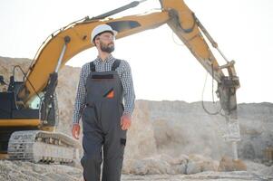 mannetje arbeider met bulldozer in zand steengroeve foto
