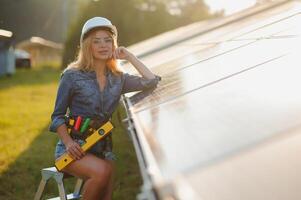 Dames ingenieur werken Aan controle en onderhoud uitrusting Bij groen energie zonne- macht fabriek foto