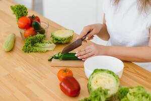 gelukkig jong huisvrouw menging groente salade foto