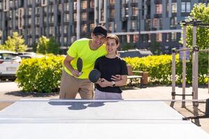 gelukkig Mens met zijn dochter spelen ping pong in park foto