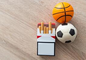 roken of sport. sport bal en pak van sigaretten Aan tafel achtergrond. top visie foto