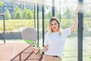 jong sportief vrouw padel speler raken bal met een racket Aan een moeilijk rechtbank foto