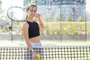 tiener- tennis speler vrouw Aan rechtbank met racket foto