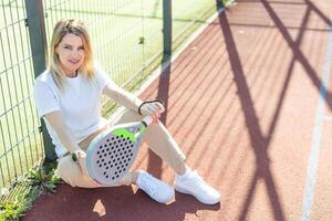 een vrouw peddelen tennis speler na spelen een wedstrijd. foto