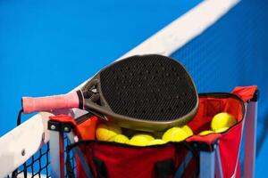 ballen in de buurt de netto van een blauw padel tennis rechtbank foto