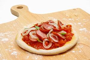 peperoni pizza met uien en tomaat saus Aan houten bord foto