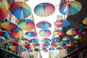 kleurrijk drijvend paraplu's hangen bovenstaand de straat gedurende trots maand foto