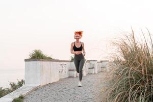 gelukkig vrouw loper jogging Aan voetpad onder Doorzichtig lucht foto