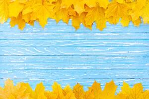 herfst bladeren kader Aan houten achtergrond top visie vallen grens geel en oranje bladeren wijnoogst hout tafel kopiëren ruimte voor tekst. foto