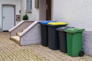 plastic containers voor vuilnis in de buurt de Ingang naar een woon- gebouw foto