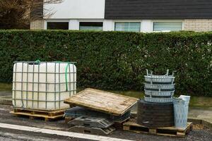 wit plastic water tank en weg tegels Aan houten pallets Bij bouw plaats foto