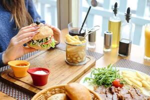 vrouw zittend Bij tafel met bord van voedsel foto