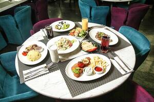 tafel met voedsel borden en blauw stoelen foto