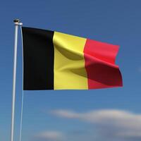 belgie vlag is golvend in voorkant van een blauw lucht met wazig wolken in de achtergrond foto
