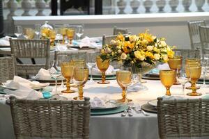 geavanceerde lunch tafel opstelling in jacht club met platen, bril, bloemen en bestek foto