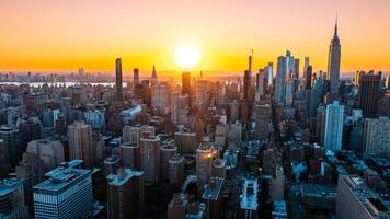 oranje licht van instelling zon verhelderend de wolkenkrabbers en hoogbouw gebouwen in nieuw york landschap. top visie Aan de metropolis van bovenstaand de oosten- rivier. foto