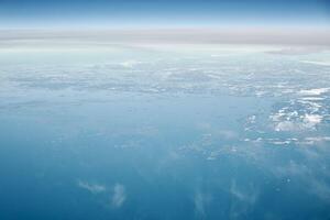 antenne visie van vliegtuig venster over- wolken top naar verkoudheid noorden zee, winter vers ijzig lucht foto