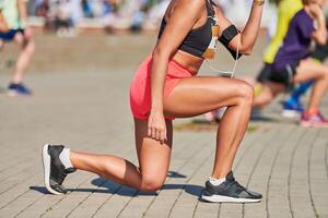 jong vrouw opwarming omhoog voordat rennen marathon foto