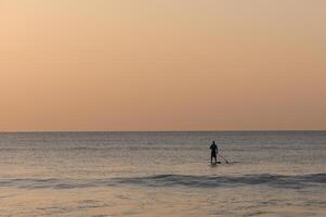 sup instappen les Aan de middellandse Zee zee in winter Bij zonsondergang 1 foto