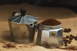 mokka pot en koffie Slijper Aan natuurlijk jute donker achtergrond. koffie maken concept. foto