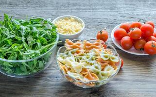 driekleur farfalle met rucola, Parmezaanse kaas en kers tomaten foto