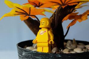 de geel astronaut Lego karakter is genieten van herfst met een glimlachen uitdrukking. foto