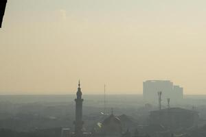 de moskee in het midden van de stad is gehuld in dikke mist. prachtige moskee gefotografeerd vanuit drone foto