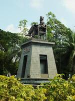 soerakarta, centraal Java, Indonesië april 11, 2024. de standbeeld van Dhr soekarno zittend terwijl lezing een boek, standbeeld van de eerste president van de republik Indonesië Bij manahan stadion. foto