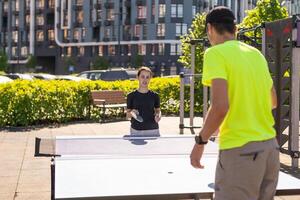 kind spelen tafel tennis buitenshuis met familie foto