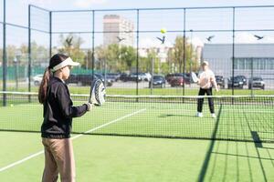 moeder en dochter spelen padel buitenshuis foto