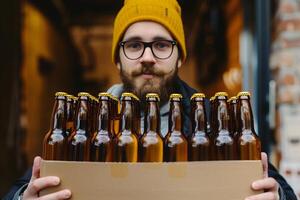 gelukkig Mens Holding geval van bier flessen buiten winkel foto