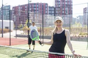 Oekraïne kiev, april 02 2024. gelukkig atletisch paar hebben pret terwijl spelen padel tennis verdubbelt bij elkaar passen Aan buitenshuis rechtbank. foto