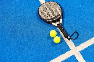 peddelen tennis racket en ballen Aan de blauw peddelen rechtbank foto