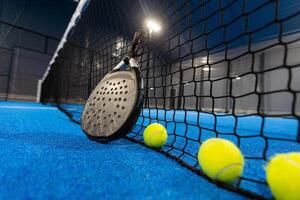 ballen in de buurt de netto van een blauw padel tennis rechtbank foto