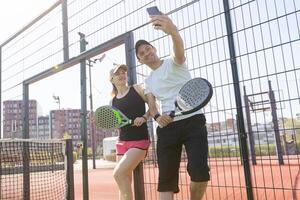 jong vrouw spelen padel tennis met partner in de Open lucht tennis rechtbank foto