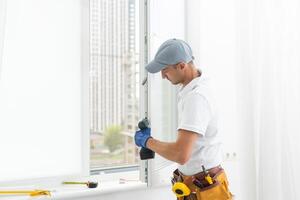 meester werk. detailopname van jong klusjesman instelling nieuw ramen Bij de appartement foto