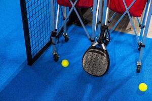 ballen in de buurt de netto van een blauw padel tennis rechtbank foto