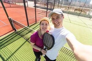 peddelen tennis vrouw en Mens team poseren in breed hoek beeld foto